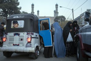 Women get in a three wheeled taxi near the Blue Mosque, in Herat, Afghanistan, Monday, Nov. 22, 2021