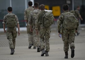 Members of the British armed forces 16 Air Assault Brigade walk to the air terminal after disembarking a RAF Voyager aircraft at Brize Norton, England, as they return from helping in operations to evacuate people from Kabul airport in Afghanistan, Saturday, Aug. 28, 2021.