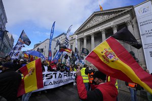 Police march past the Spanish parliament during a protest march in Madrid, Spain, Saturday, Nov. 27, 2021.