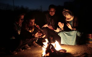 Yemeni boys gather around a fire to warm themselves from the evening cold in the outskirts of Sanaa, Yemen, Saturday, Dec. 31, 2016.