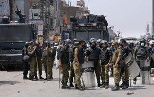 Police officers prepare to leave after conducting a crackdown against supporters of Tehreek-e-Labiak Pakistan, a banned Islamist party, protesting the arrest of their party leader, in Lahore, Pakistan, Sunday, April 18, 2021.