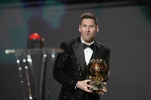 PSG player Lionel Messi reacts after winning the 2021 Ballon d'Or trophy during the 65th Ballon d'Or ceremony at Theatre du Chatelet, in Paris, Monday, Nov. 29, 2021