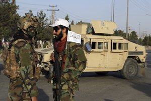 Taliban fighters stand guard at a checkpoint near the gate of Hamid Karzai international Airport in Kabul, Afghanistan, Saturday, Aug. 28, 2021.