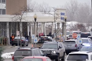 Police are shown in the parking lot of a Meijer store where Oxford High School students were being reunited with parents in Oxford