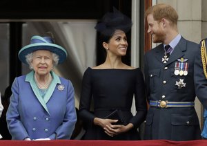 FILE - In this Tuesday, July 10, 2018 file photo Britain's Queen Elizabeth II, and Meghan the Duchess of Sussex and Prince Harry watch a flypast of Royal Air Force aircraft pass over Buckingham Palace in London.