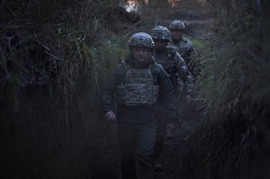 Ukrainian President Volodymyr Zelenskyy surrounded by servicemen as he visits the war-hit Donetsk region, eastern Ukraine, on Oct. 14, 2021