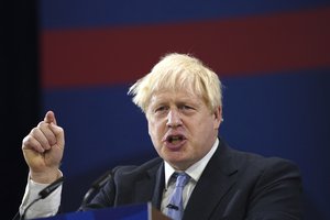 Britain's Prime Minister Boris Johnson gestures as he makes his keynote speech at the Conservative party conference in Manchester, England, Wednesday, Oct. 6, 2021.