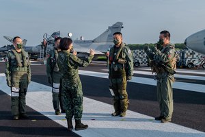 File - In this photo released by the Taiwan Presidential Office, Taiwanese President Tsai Ing-wen, center, speaks with military personnel near aircraft parked on a highway in Jiadong, Taiwan, Wednesday, Sept. 15, 2021.