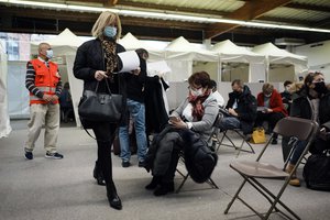 People wait during an observation period after having received Pfizer's COVID-19 vaccine at a vaccination site, in Fontainebleau, south of Paris, Friday, Dec. 3, 2021