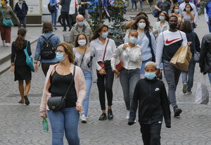 People walk in a shopping area while wearing a protective face masks as a precaution against the coronavirus in Paris, Friday, Aug. 28, 2020