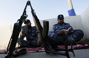 A Palestinian Hamas policemen read the Koran in Rafah, southern Gaza Strip on July 23, 2012. Muslims around the world refrain from eating, drinking and sexual intercourse from dawn till dusk during Ramadan, the holiest month in the Islamic calendar. Policemen read the Koran during the day hours, while they cannot eat.Photo by Ahmed Deeb / WN