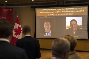 A video screen displays images of Canadians Michael Kovrig, left, and Michael Spavor at an event held in connection with the announcement of the sentence for Spavor at the Canadian Embassy in Beijing, Wednesday, Aug. 11, 2021