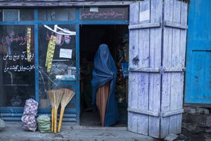 An Afghan woman wearing a burka exits a small shop in Kabul, Afghanistan, Sunday, Dec. 5, 2021.