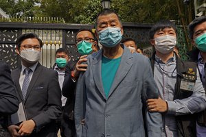 File - Hong Kong media tycoon Jimmy Lai, center, who founded local newspaper Apple Daily is arrested by police officers at his home in Hong Kong, Saturday, April 18, 2020.