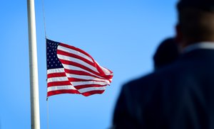 Ceremony of USAF Airmen salutes flag of the US displayed at half-staff