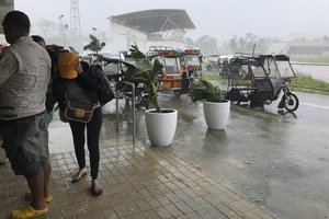 Storm evacuees take cover as strong winds blow in Dapa town, Siargao, Surigao del Norte province, southern Philippines on Thursday, Dec. 16, 2021.