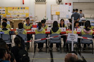 Election workers count ballots at a polling station during local election in Hong Kong