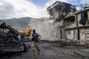 A building damaged when a gasoline truck overturned and exploded the previous day, killing dozens, is demolished in Cap-Haitien, Haiti, Wednesday, Dec. 15, 2021.