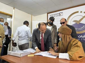 FILE - Seif al-Islam, right, the son and one-time heir apparent of late Libyan dictator Moammar Gadhafi registers his candidacy for the country's presidential elections next month, in Sabha, Libya, Sunday, Nov. 14, 2021.