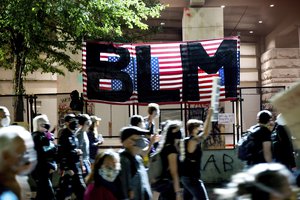 In this July 31, 2020, file photo, Black Lives Matter protesters march past the Mark O. Hatfield United States Courthouse in Portland, Ore. The federal government deliberately targeted Black Lives Matter protesters via heavy-handed criminal prosecutions in an attempt to disrupt and discourage the global movement.