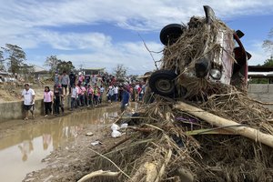 In this handout photo provided by the Office of the Vice-President, Philippine Vice-President Leni Robredo, second from left, walks beside beside a damaged vehicle due to Typhoon Rai at Negros Oriental, central Philippines on Tuesday Dec. 21, 2021.