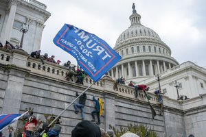 File - Support of President Donald Trump climb the West wall of the the U.S. Capitol on Wednesday, Jan. 6, 2021, in Washington.