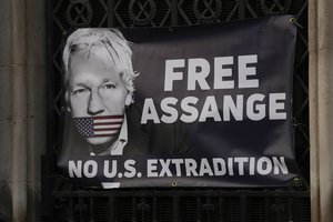 A view of a banner Julian Assange supporters fixed to a railing, outside the High Court in London, Friday, Dec. 10, 2021