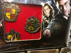 Harry Potter pins, and pendants for sale at a toy convention. Taken on June 2017.