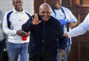 FILE- In this Monday May 6, 2019. file photo Anglican Archbishop Emeritus Desmond Tutu exits his home in Cape Town, South Africa