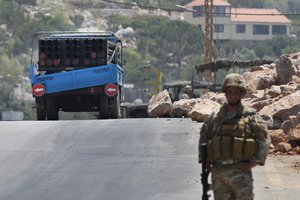 A Lebanese army soldier stands next of a rocket launcher placed on a pick up truck that was used by Hezbollah to fire rockets near Israeli positions, in the southeastern village of Shwaya, near the border with the Golan Heights, Friday, Aug. 6, 2021