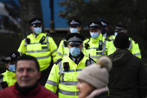 Police officers wear face masks as they patrol an anti-lockdown demonstration in Parliament Square, in London, Monday, Dec. 14, 2020