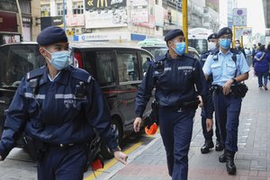 File - Police officers guard outside the building of  “Stand News” office in Hong Kong Wednesday, Dec. 29, 2021.