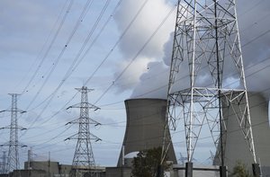 Steam billows from a nuclear power plant next to utility lines in Doel, Belgium, Monday, Oct. 11, 2021.