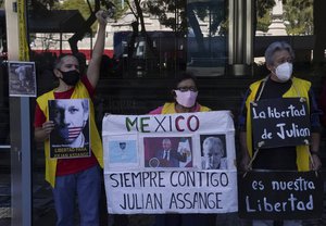 Julian Assange supporters hold a sign that reads in Spanish "Mexico always with you," during a protest in front of the British Embassy in Mexico City, Wednesday, Dec. 22, 2021.