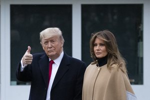 President Donald Trump, accompanied by first lady Melania Trump, gives thumbs up as he walks on the South Lawn