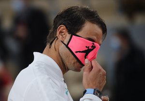 Rafael Nadal's face mask covers his eyes as he celebrates winning the final match of the French Open tennis tournament against Serbia's Novak Djokovic