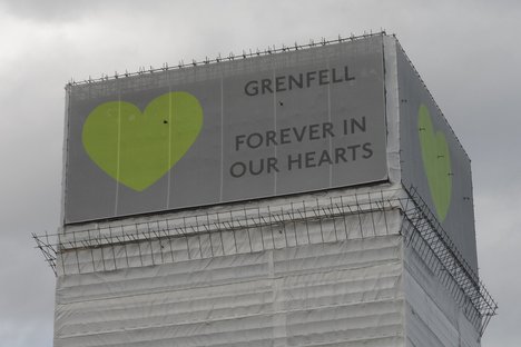 Grenfell Tower with banners at the top with heart symbol and the wording "Grenfell Forever In Our Hearts"