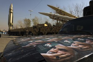 ADDS NAMES OF MISSILES - Posters of Iranian Gen. Qassem Soleimani, who was killed in Iraq in a U.S. drone attack in Jan. 3, 2020, are seen in front of Qiam, background left, Zolfaghar, top right, and Dezful missiles displayed in a missile capabilities exhibition by the paramilitary Revolutionary Guard a day prior to second anniversary of Iran's missile strike on U.S. bases in Iraq in retaliation for killing Gen. Soleimani, at Imam Khomeini grand mosque, in Tehran, Iran, Friday, Jan. 7, 2022.