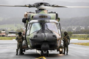 In this photo released by the Australian Department of Defence, Royal Australian Navy aircrew from the 808 Squadron, stand beside their MRH90 Taipan helicopter in Wollongong, Australia, Nov. 27, 2021.