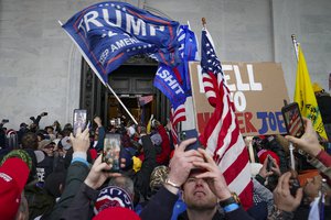 In this Jan. 6, 2021, file photo, Trump supporters gather outside the Capitol in Washington. Some people charged with storming the U.S. Capitol on Jan. 6 are claiming they were only there to record history as journalists, not join a deadly insurrection.