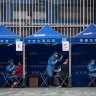 People receive COVID-19 PCR tests at a testing facility in the Tuen Mun area of Hong Kong.