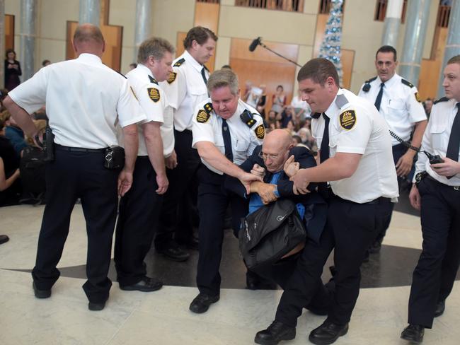 Protesters are removed ... by security after attending a rally inside Parliament House. Picture: AAP