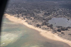 In this photo provided by the New Zealand Defense Force, volcanic ash covers roof tops and vegetation in an area of Tonga, Monday, Jan. 17, 2022.