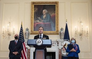 Secretary of State Antony Blinken speaks in the Benjamin Franklin Room of the State Department in Washington, Friday, Nov. 5, 2021., as Jonathan Moore, left, and retired ambassador Margaret Uyehara listen.