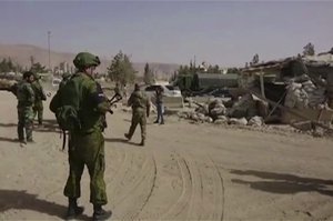 In this is frame grab from video, Syrian government forces and Russian soldiers oversee the evacuation by buses of rebel fighters and their families, at a checkpoint in eastern Gouta, Syria, Thursday March, 22, 2018