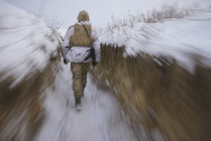 A Ukrainian serviceman walks through a trench on the front line in the Luhansk area, eastern Ukraine, Thursday, Jan. 27, 2022