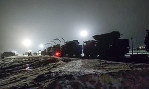 In this photo taken from video provided by the Russian Defense Ministry Press Service on Saturday, Jan. 29, 2022, Russian military vehicles prepares to drive off a railway platforms after arrival in Belarus