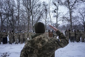 Members of Ukraine's Territorial Defense Forces, volunteer military units of the Armed Forces stay in line before training in Kharkiv, Ukraine, Saturday, Jan. 29, 2022. Some people in Ukraine's second-largest city are preparing to fight back if Russia invades.