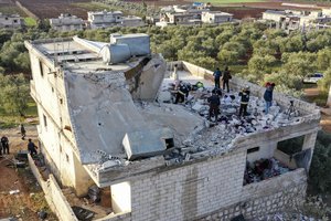 People inspect a destroyed house following an operation by the U.S. military in the Syrian village of Atmeh, in Idlib province, Syria, Thursday, Feb. 3, 2022. U.S. special operations forces conducted a large-scale counterterrorism raid in northwestern Syria overnight Thursday, in what the Pentagon said was a “successful mission.” Residents and activists reported multiple deaths including civilians from the attack.