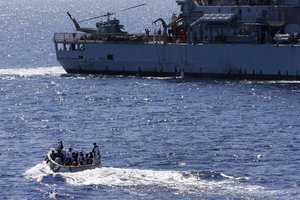 FILE - Migrants are transferd by Italian sailors from the German combat supply ship 'Frankfurt am Main' to the their ship 'Grecale' after being rescued during EUNAVFOR MED Operation Sophia in the Mediterranean Sea off the coast of Libya on March 29, 2016.